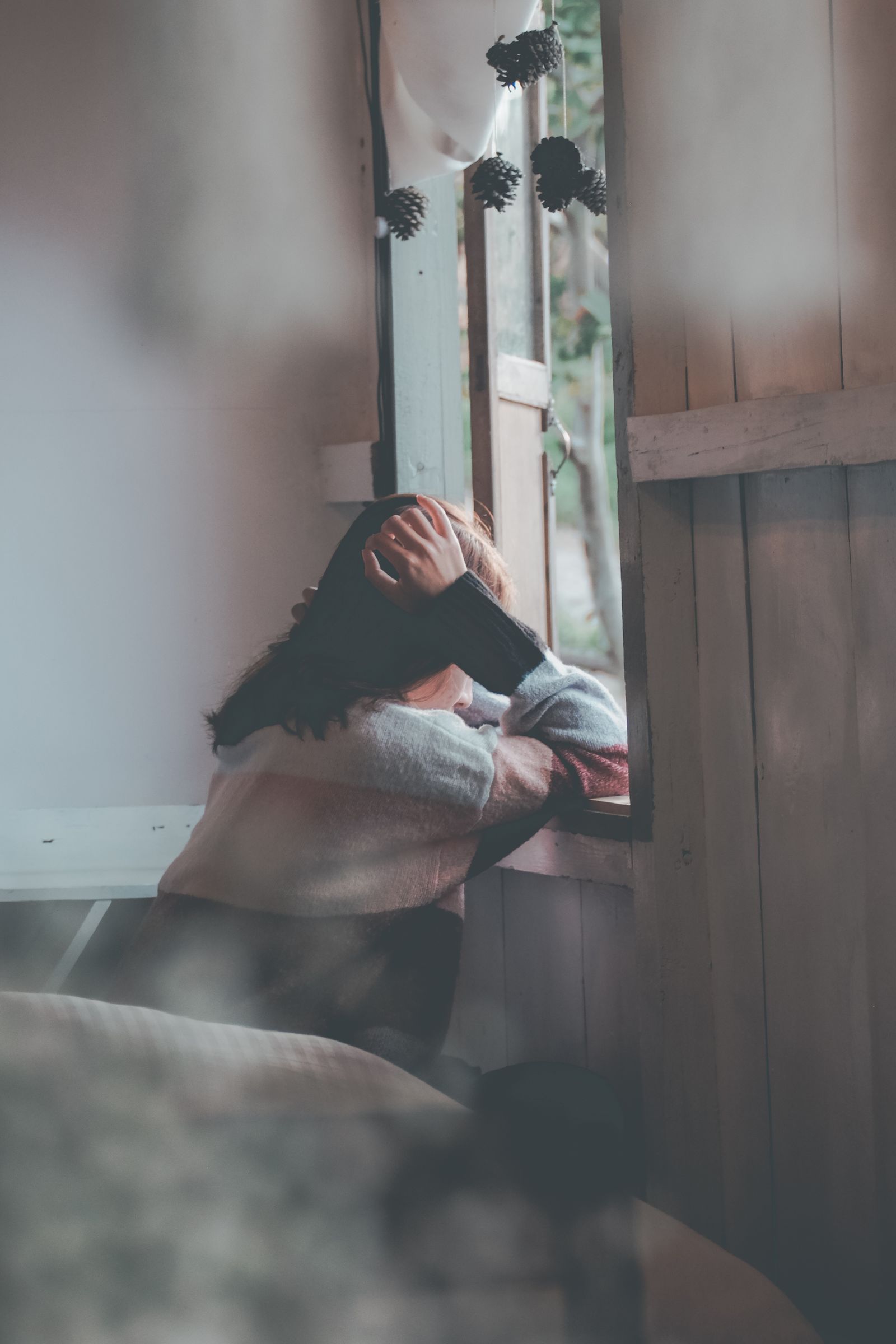 An au pair feeling lonely by a window
