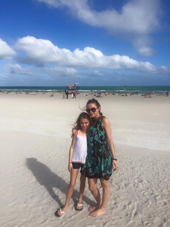 A host mother and her child together on the beach